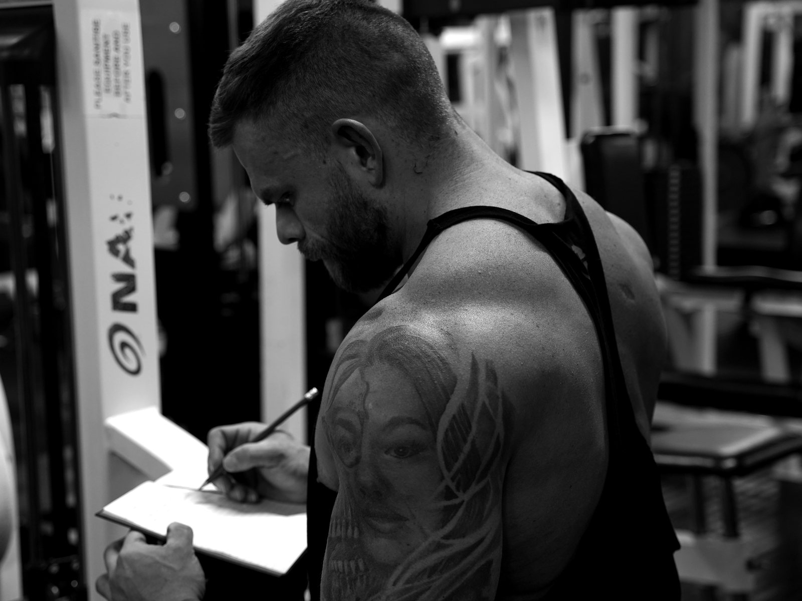 Jack Wall writing in a training logbook in the gym